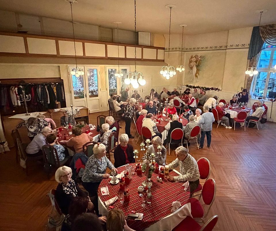 Seniorenweihnachtsfeier in Osterweddingen Senioren sitzen jewils zu sechst um an weihnachtslich geschmückten Tischen