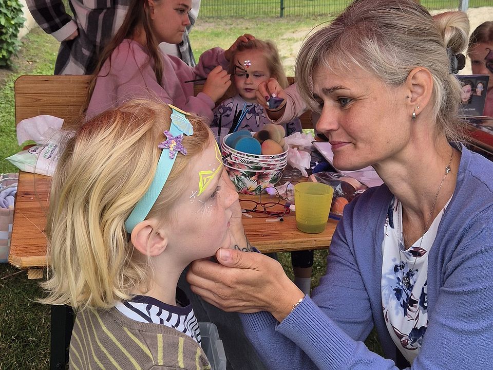 Eine Frau schminkt ein Kind