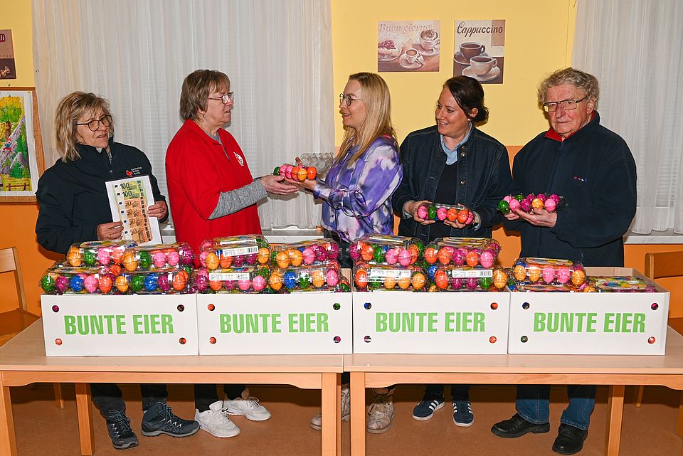 Ostereierspende für die Tafel in Wanzleben 5 Personen stehen hinter einem Tisch mit mehreren Kisten bunter Eier