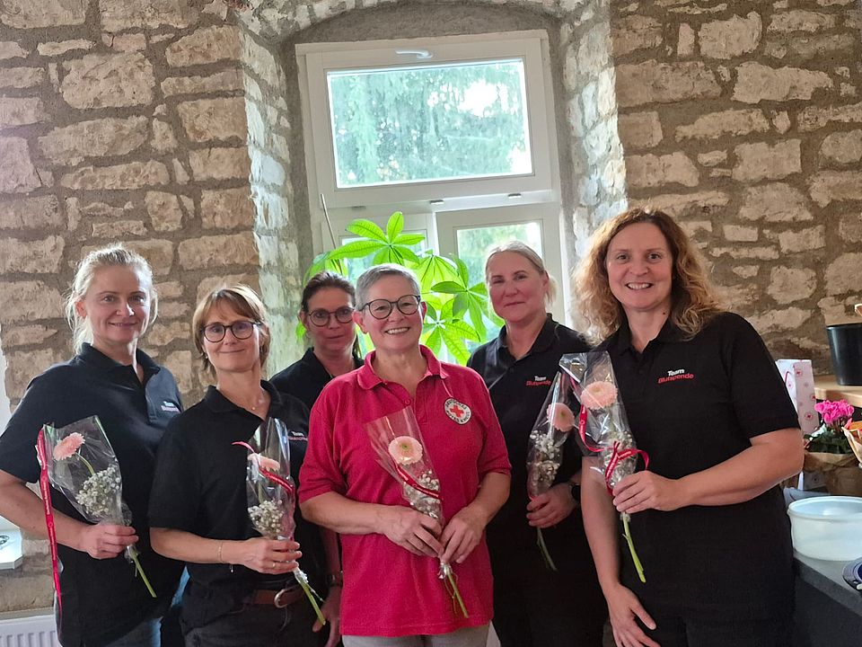 Der neue Vorstand des Ortsvereins Ummendorf 6 Frauen stehen vor einem Fenster und halten Blumen in der Hand