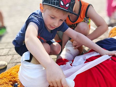 kleiner Junge verbindet Teddy Bruno die Nase