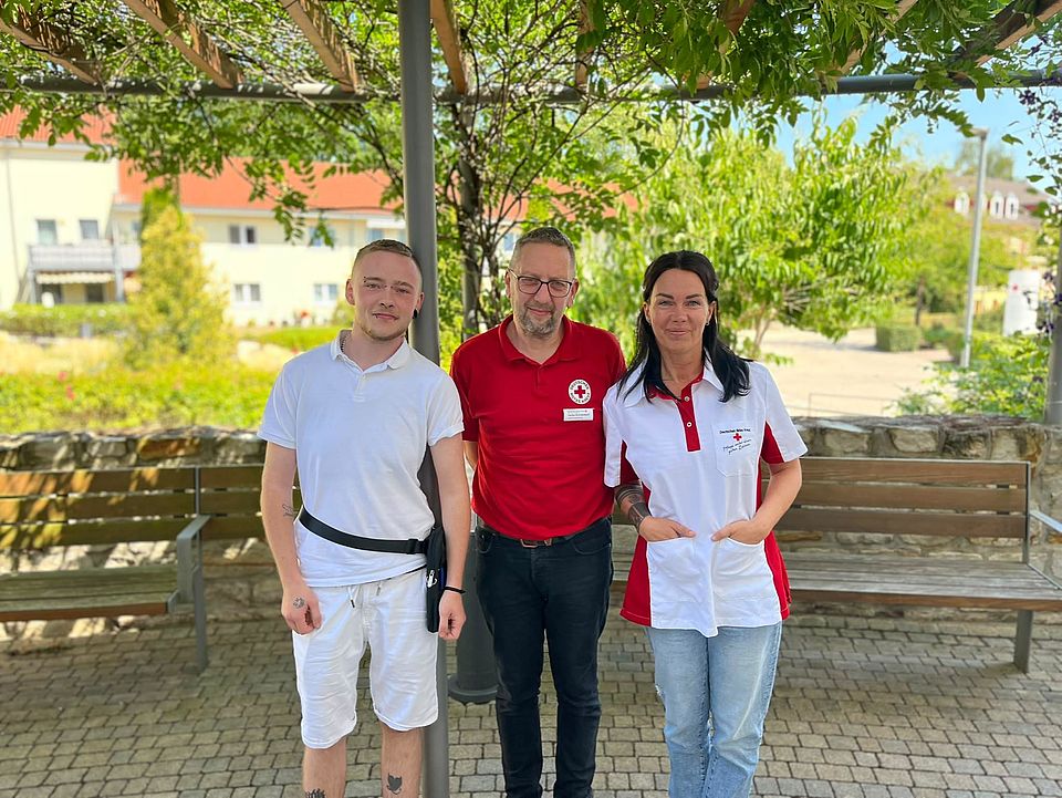 Heiko Kricheldorf begrüße zwei neue Azubis Zwei Männer und eine Frau stehen unter einer Pergola