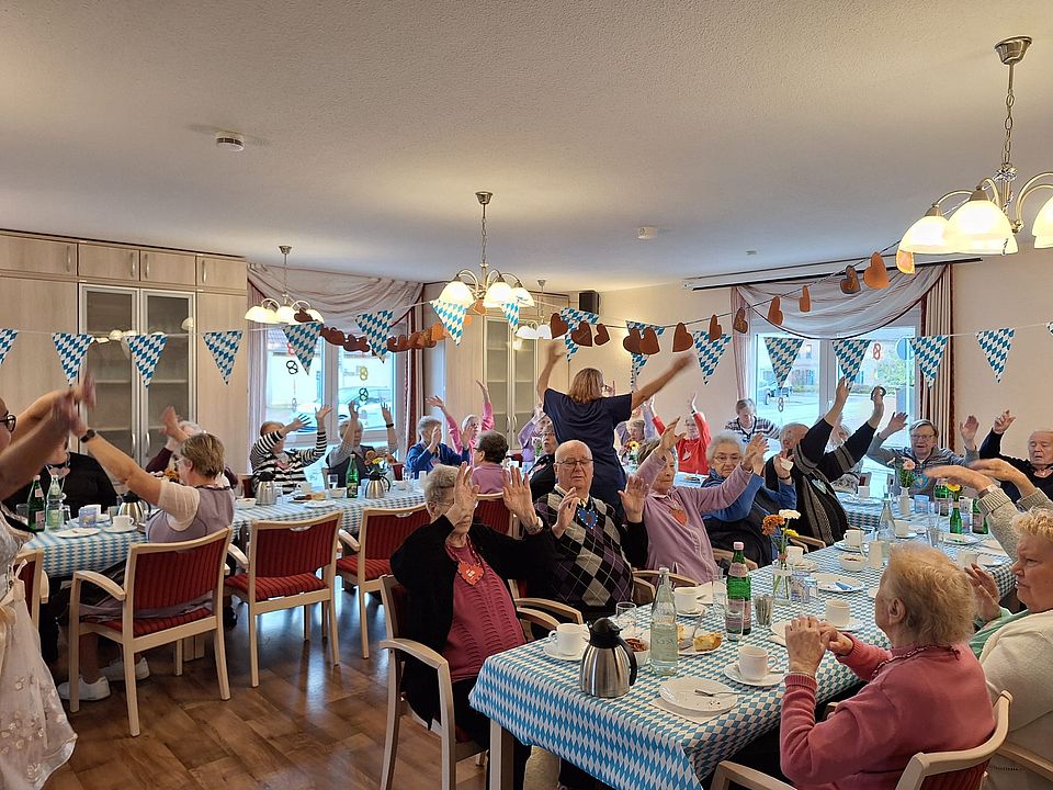 Ausgelassenes feiern zum Oktoberfest in Eilsleben Viele Senioren sitzen an der Kaffeetafel und winken mit den Armen