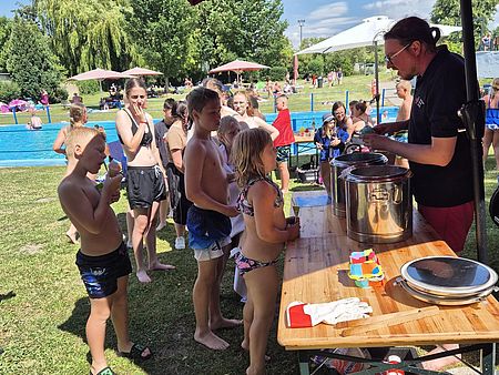 Kinder im Schwimmbag stehen nach Eis an