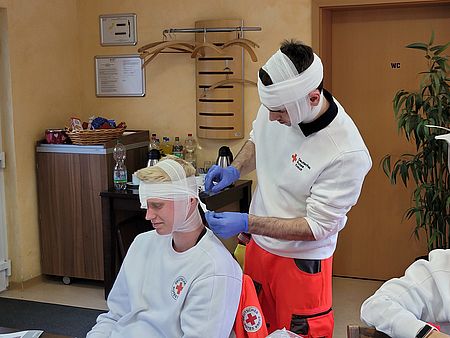 Zwei Sanitäter in Ausbildung verbinden sich gegenseitig am Kopf